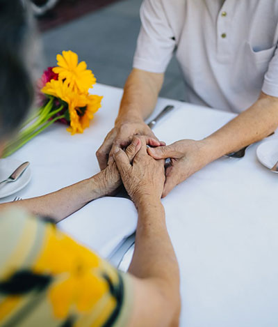 couple holding hands on the dinner table