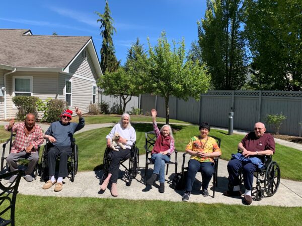 group of elderly sitting in the courtyard waving to the camera
